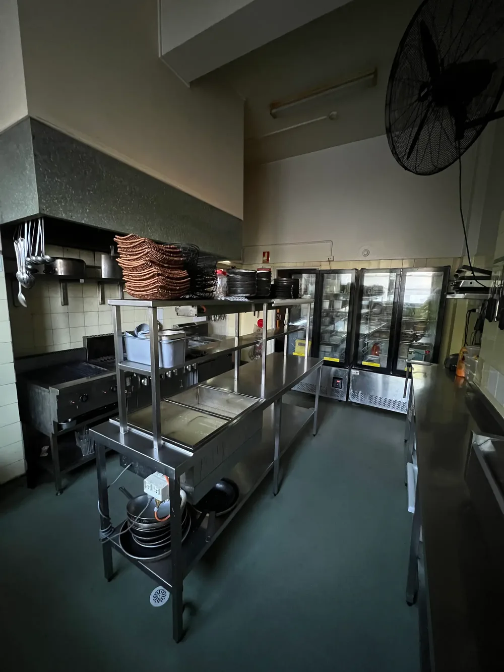 Commercial kitchen with stainless steel prep benches and display fridges, serviced by Elite Building & Pest
