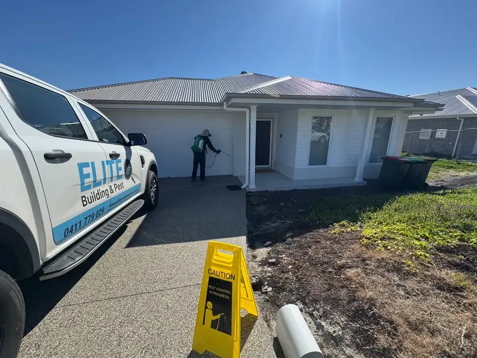 Elite Building & Pest technician and van at a home during a pest control treatment