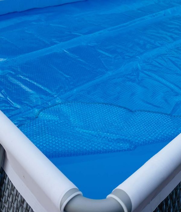 Pool cover. Blue solar film on the pool. Selective focus.